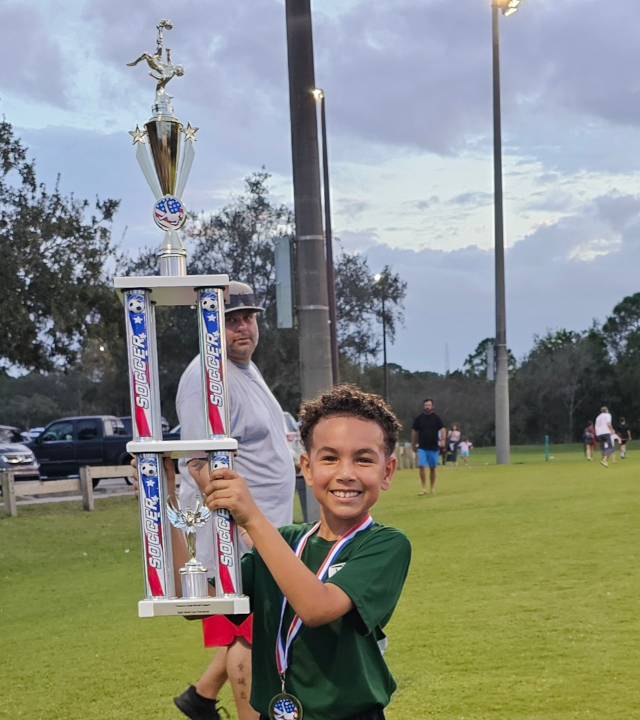 Vincenzo holding trophy